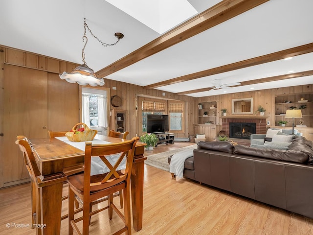431 N Brainard Ave, La Grange Park, IL 60526 - dining room featuring a brick fireplace, light wood-type flooring, a ceiling fan, wooden walls, and beam ceiling