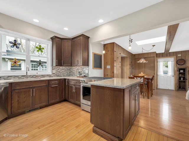 431 N Brainard Ave, La Grange Park, IL 60526 - kitchen with light wood-style flooring, light stone countertops, visible vents, appliances with stainless steel finishes, and a sink