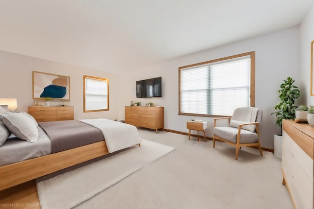 bedroom featuring baseboards and light carpet