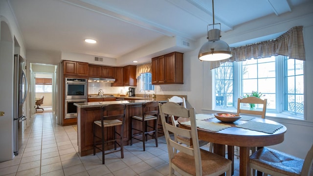 1336 Christina Ln, Northbrook, IL 60062 - kitchen featuring a healthy amount of sunlight, under cabinet range hood, visible vents, and appliances with stainless steel finishes