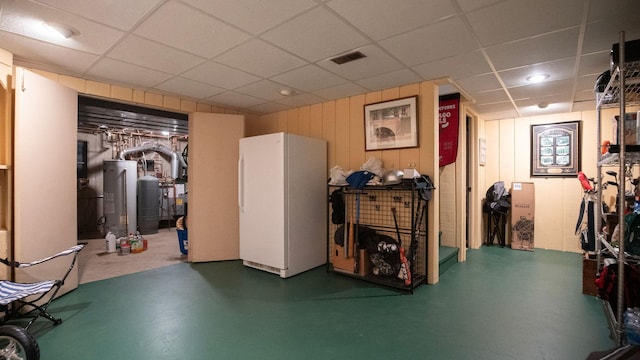 1336 Christina Ln, Northbrook, IL 60062 - finished below grade area featuring water heater, visible vents, freestanding refrigerator, and a paneled ceiling