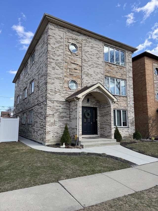 2915 N 74th Ave Unit 2, Elmwood Park, IL 60707 - view of front facade with brick siding, a front lawn, and fence