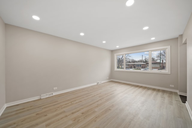 empty room with recessed lighting, visible vents, light wood-type flooring, and baseboards