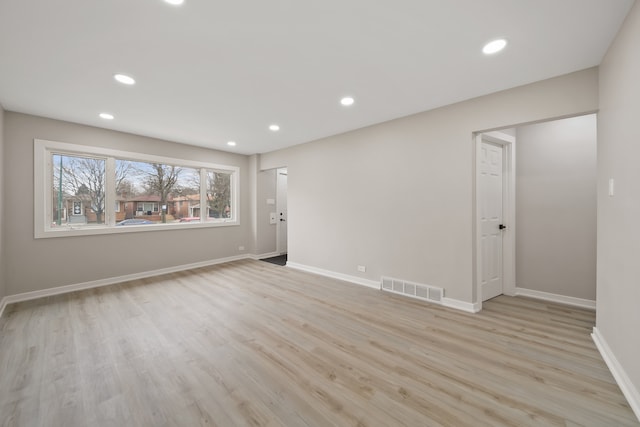 empty room featuring light wood finished floors, baseboards, visible vents, and recessed lighting
