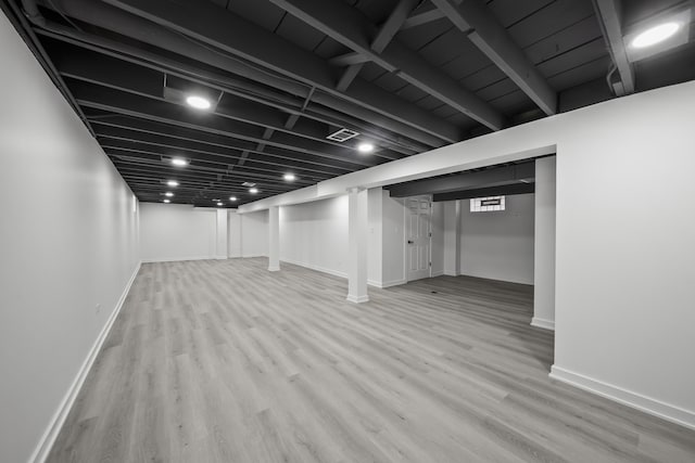 finished basement featuring visible vents, baseboards, and wood finished floors