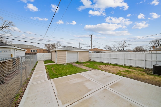 view of yard with a patio, central air condition unit, an outdoor structure, a detached garage, and a fenced backyard