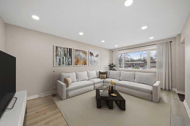 living room featuring light wood-style flooring, recessed lighting, and baseboards