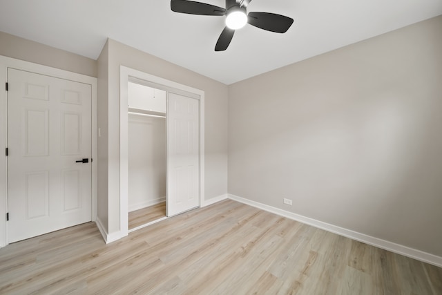 unfurnished bedroom with ceiling fan, a closet, light wood finished floors, and baseboards