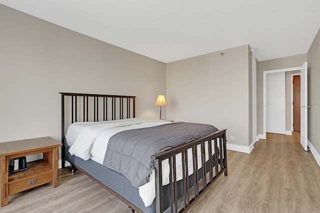 bedroom with light wood-type flooring and baseboards