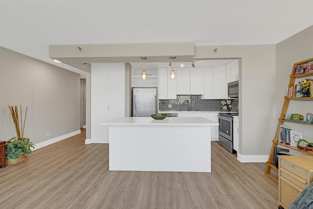 kitchen featuring appliances with stainless steel finishes, light wood finished floors, tasteful backsplash, light countertops, and baseboards