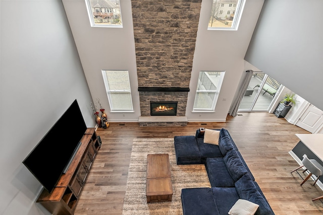 living room featuring a high ceiling, wood finished floors, and a healthy amount of sunlight