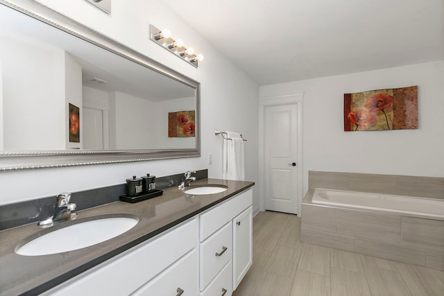 full bath featuring double vanity, visible vents, a sink, and a garden tub