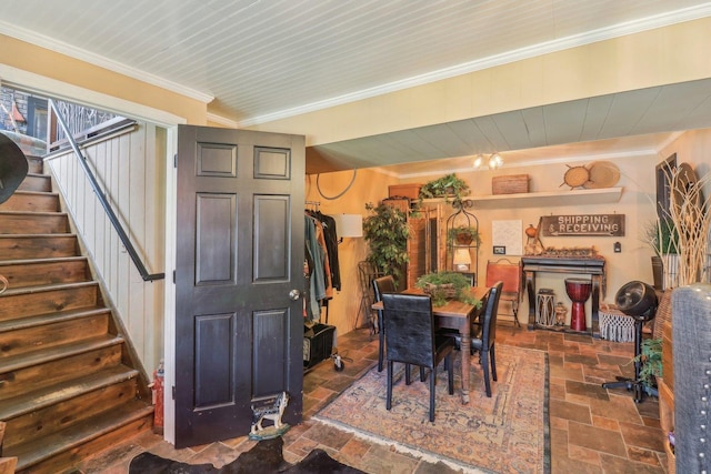 dining area with ornamental molding, stone tile flooring, and stairway