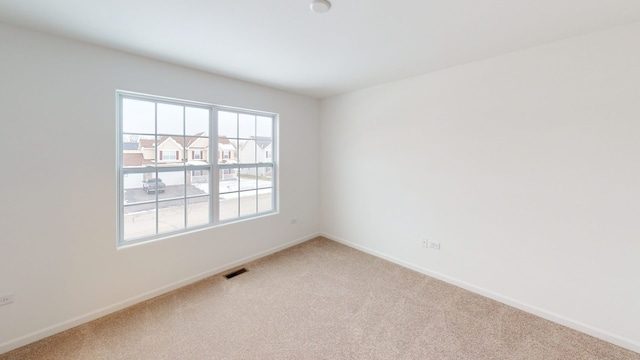 unfurnished room with visible vents, baseboards, and carpet