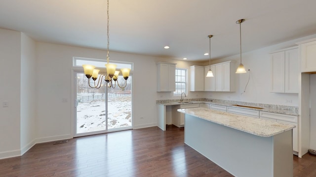kitchen featuring a notable chandelier, dark wood-style flooring, recessed lighting, a kitchen island, and a sink