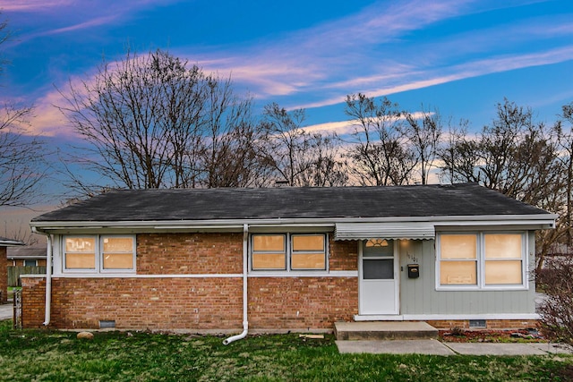 exterior space with brick siding, a yard, and crawl space