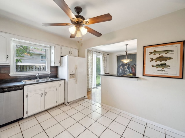 201 41st St, Downers Grove, IL 60515 - kitchen featuring stainless steel dishwasher, white refrigerator with ice dispenser, a sink, dark countertops, and white cabinetry