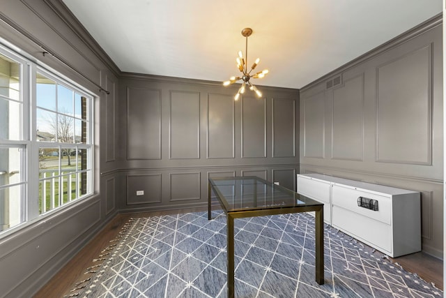 unfurnished office with a decorative wall, an inviting chandelier, dark wood-style floors, and visible vents