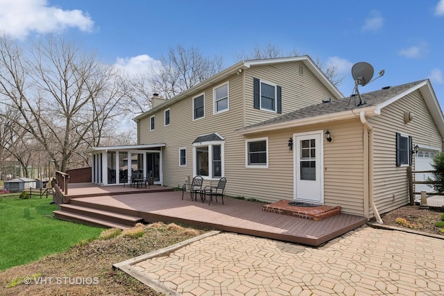 back of house featuring a yard, a deck, a sunroom, and a chimney
