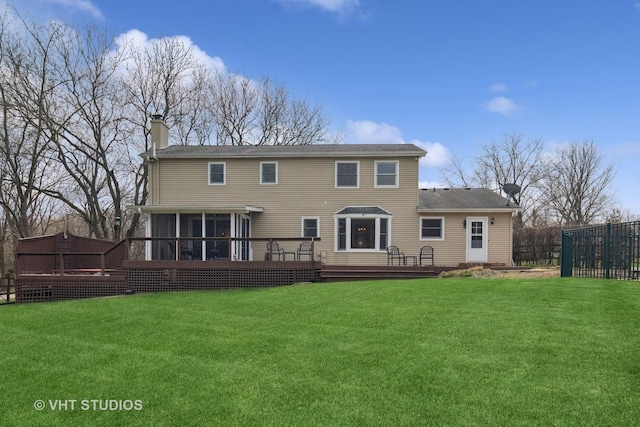 back of house with fence, a wooden deck, a lawn, and a chimney