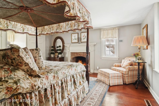 1930 Camphill Cir, Inverness, IL 60067 - bedroom with hardwood / wood-style flooring, a warm lit fireplace, visible vents, and baseboards