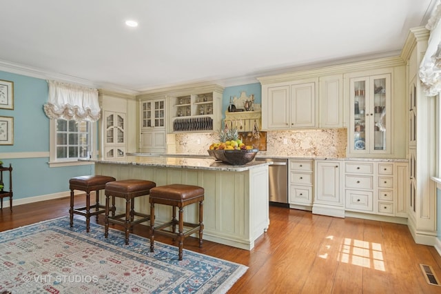1930 Camphill Cir, Inverness, IL 60067 - kitchen featuring cream cabinetry, visible vents, stainless steel dishwasher, a kitchen island, and decorative backsplash