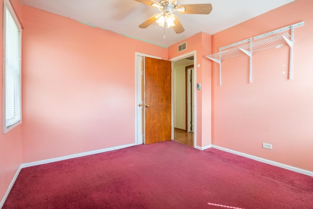 unfurnished bedroom with carpet flooring, a ceiling fan, baseboards, and visible vents
