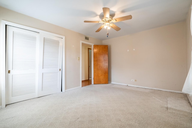 unfurnished bedroom with carpet flooring, baseboards, visible vents, a ceiling fan, and a closet