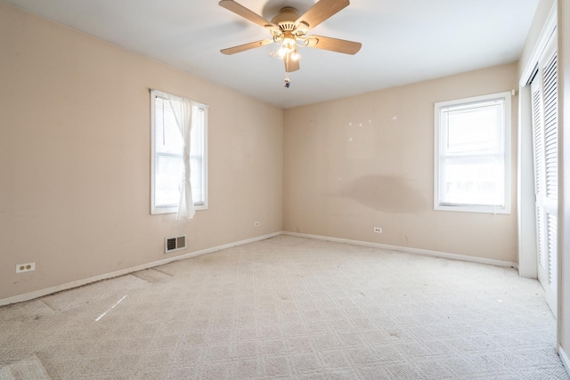 unfurnished bedroom featuring a closet, visible vents, baseboards, a ceiling fan, and light carpet