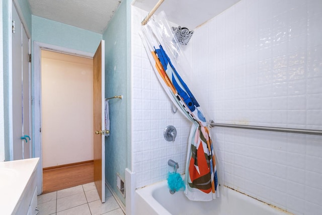 bathroom featuring vanity, shower / bath combo, a textured ceiling, tile patterned flooring, and tile walls