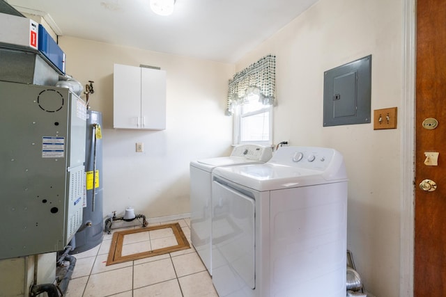 clothes washing area featuring electric panel, gas water heater, washer and dryer, cabinet space, and light tile patterned floors