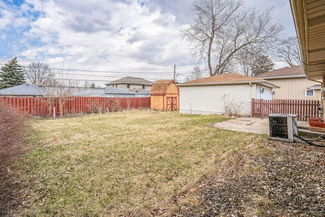 view of yard featuring an outdoor structure, a fenced backyard, a shed, and cooling unit