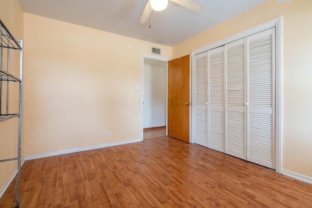 unfurnished bedroom with visible vents, baseboards, a closet, and wood finished floors
