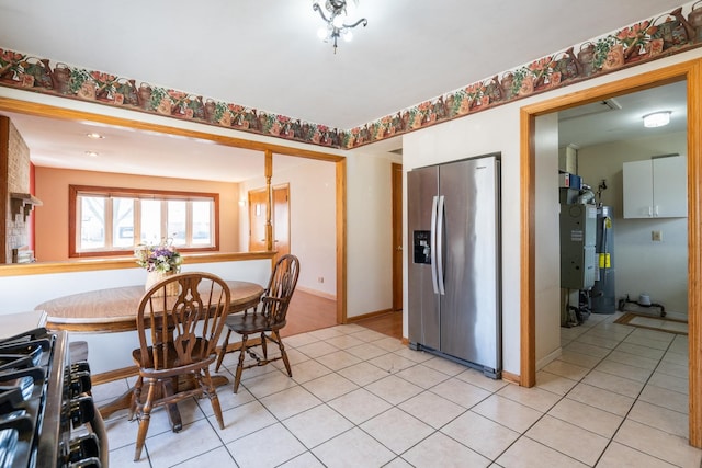 dining area featuring gas water heater, baseboards, and light tile patterned floors