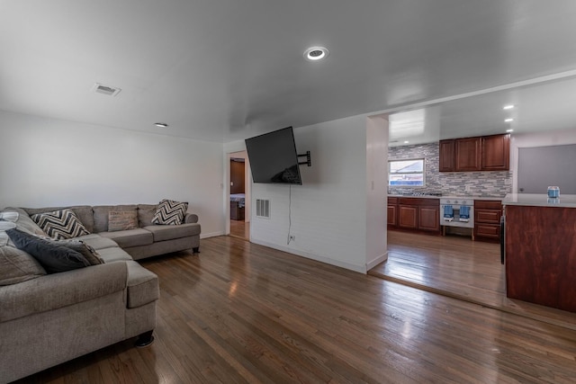 living area featuring baseboards, visible vents, and dark wood-type flooring