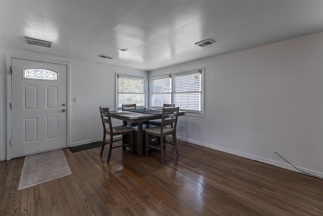 dining area featuring baseboards, dark wood-style flooring, and visible vents