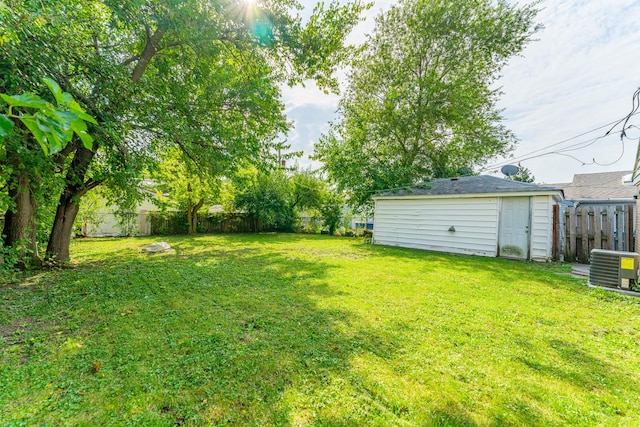 view of yard with central air condition unit and fence