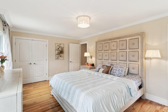 bedroom with crown molding, a closet, baseboards, and light wood-type flooring