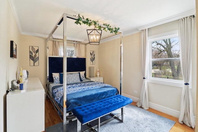 bedroom with crown molding, baseboards, multiple windows, and light wood-type flooring
