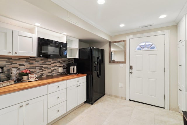 kitchen with white cabinets, ornamental molding, butcher block counters, black appliances, and backsplash