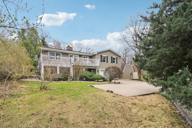 rear view of property with a deck, a storage shed, a lawn, a chimney, and an outbuilding