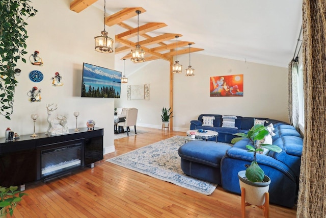 living area with wood-type flooring, baseboards, a notable chandelier, and lofted ceiling with beams