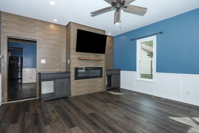 114 W Columbia St, Danvers, IL 61732 - unfurnished living room featuring visible vents, wainscoting, a fireplace, ceiling fan, and dark wood-style floors