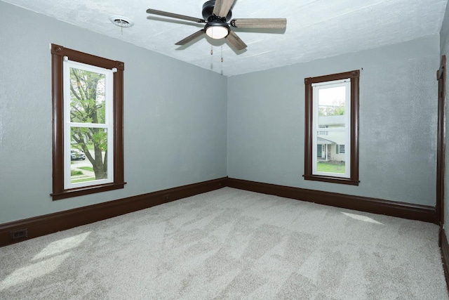 114 W Columbia St, Danvers, IL 61732 - carpeted empty room with visible vents, a ceiling fan, baseboards, and a wealth of natural light