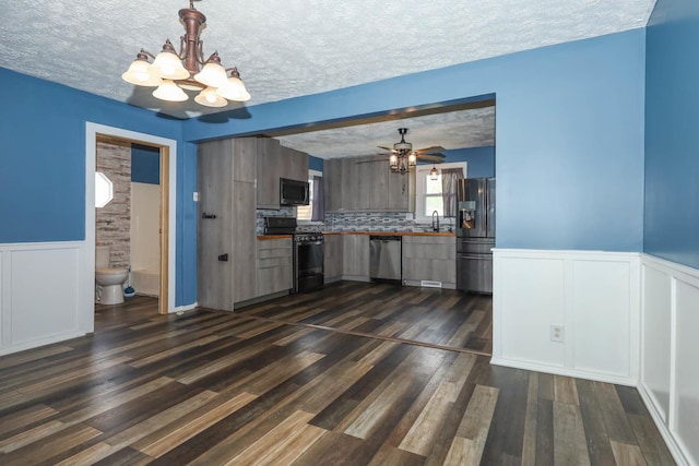 114 W Columbia St, Danvers, IL 61732 - kitchen featuring dark wood-type flooring, a textured ceiling, ceiling fan with notable chandelier, and stainless steel appliances