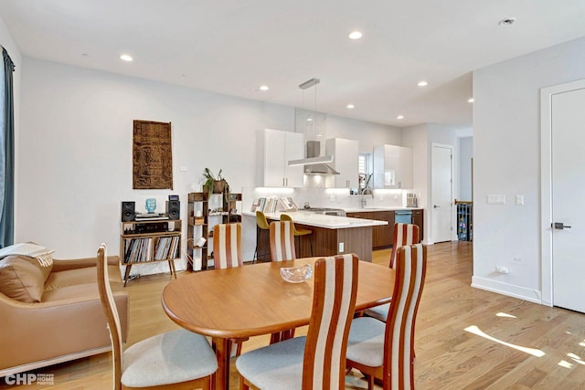 dining room with light wood-type flooring, baseboards, and recessed lighting