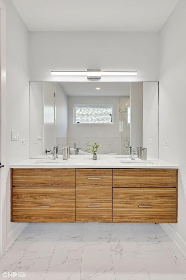 full bathroom with double vanity, marble finish floor, and a sink
