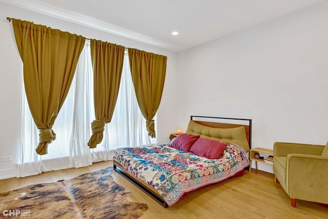 bedroom featuring baseboards, light wood-type flooring, and recessed lighting