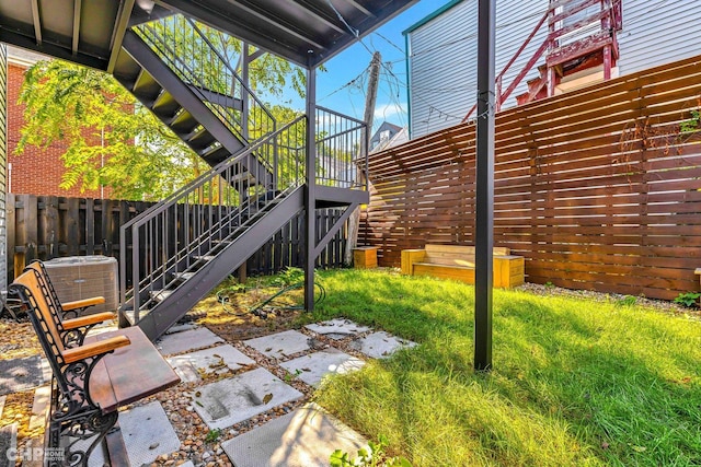 exterior space with cooling unit, fence, and stairway