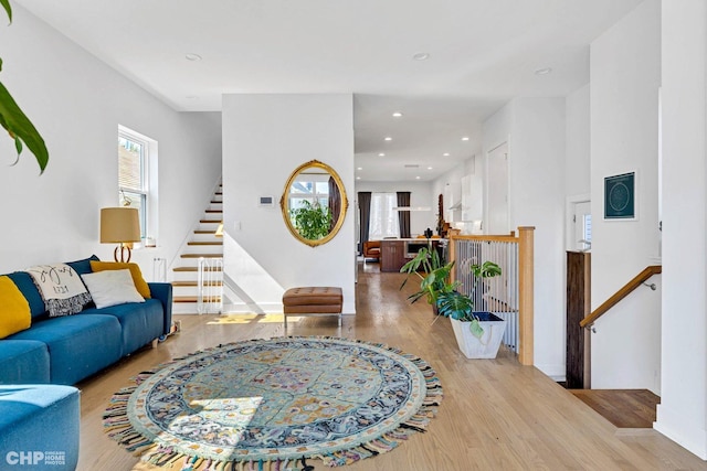 living area featuring baseboards, recessed lighting, wood finished floors, and stairs